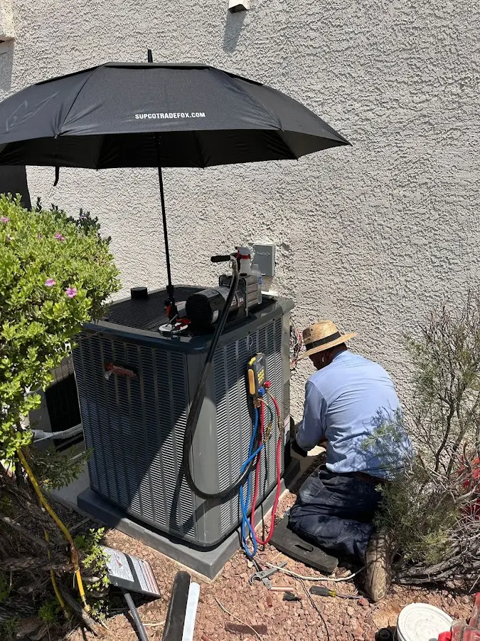HVAC technician performing outdoor AC maintenance in Loveland