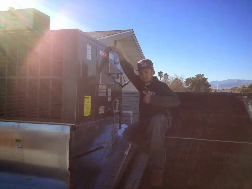 HVAC technician performing AC Tune-Up on a rooftop unit in Loveland